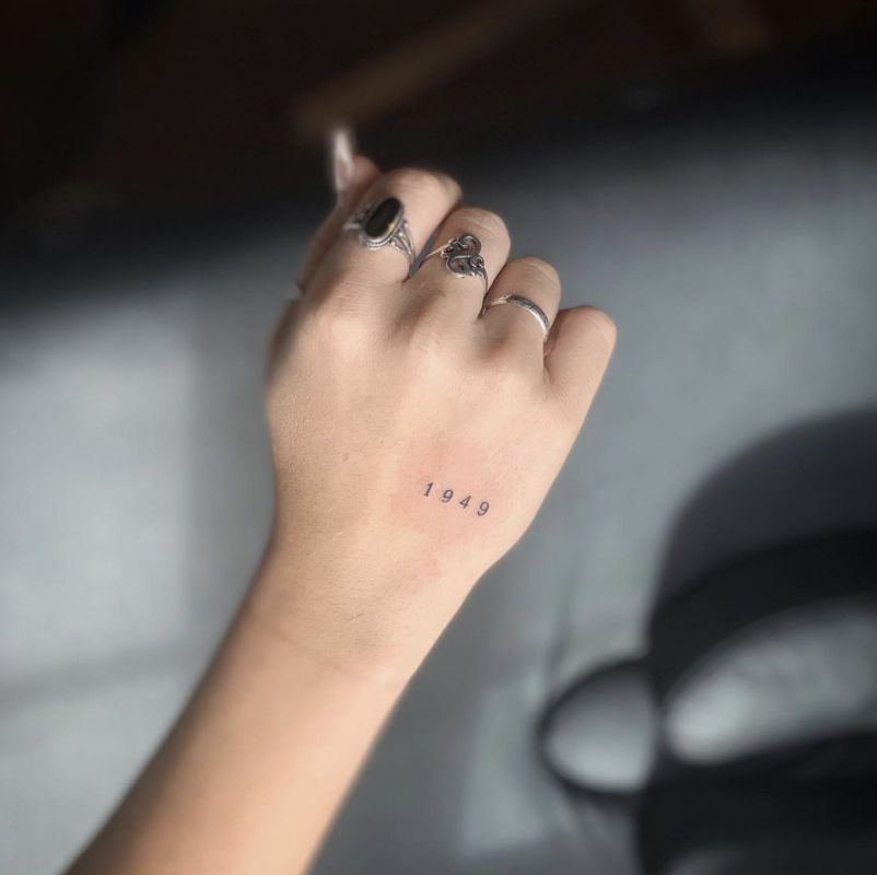 Pequena tatuagem à mão com o número 1949