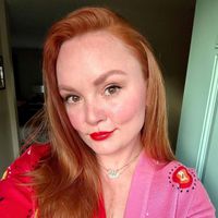 Selfie Rebecca Norris com cabelos colocados de lado. Ela usa batom vermelho.