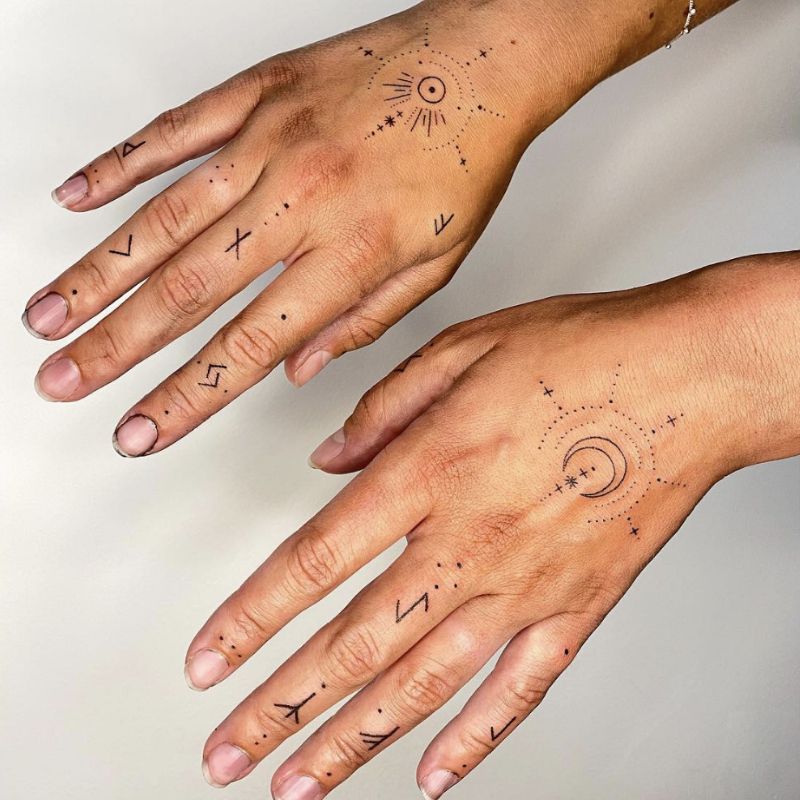 Tatuagem ornamentada no braço com o sol, lua e outros símbolos