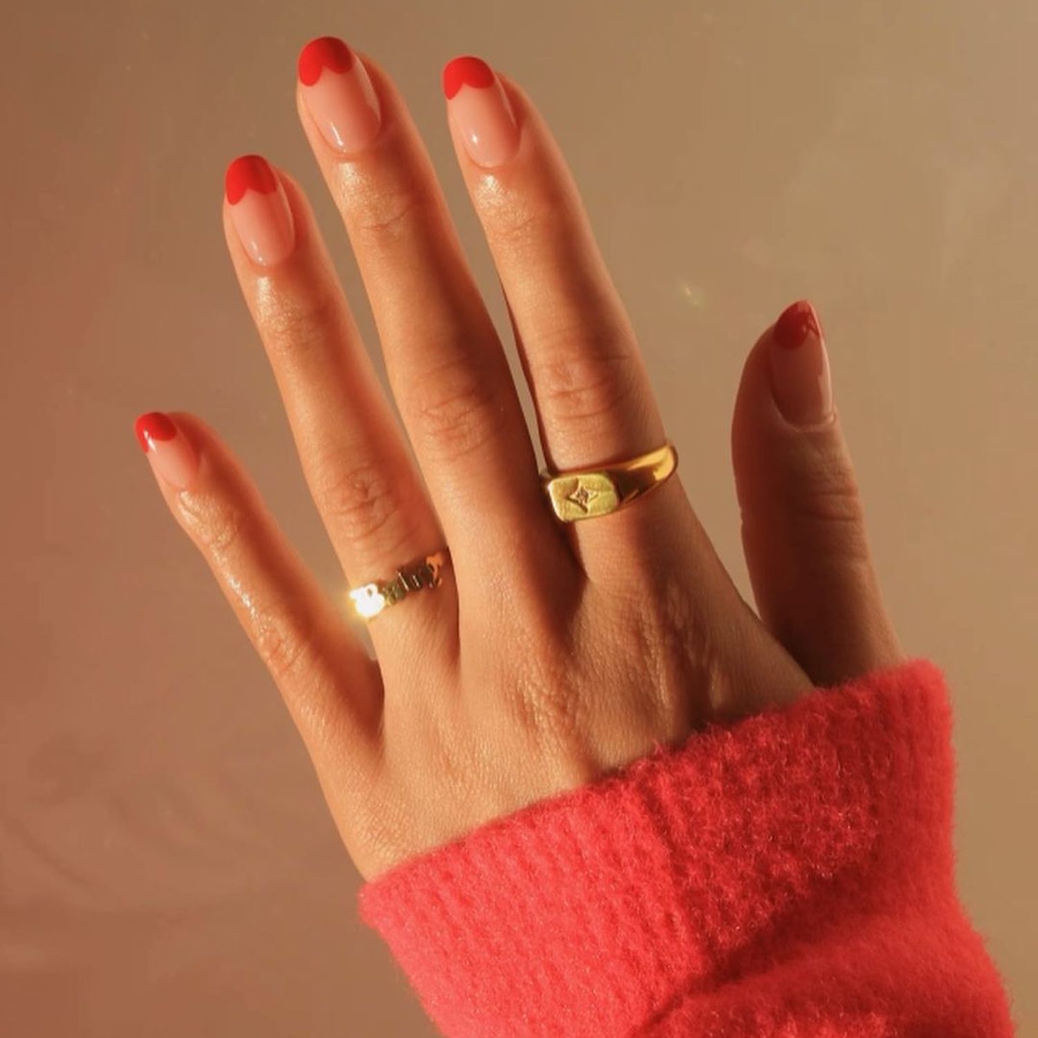 Manicure vermelha com uma ponta francesa e um design em forma de coração