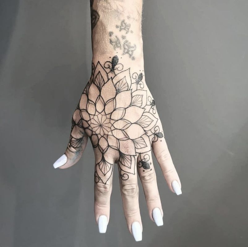 Uma grande tatuagem na mão na forma de uma mandala com um espaço negativo