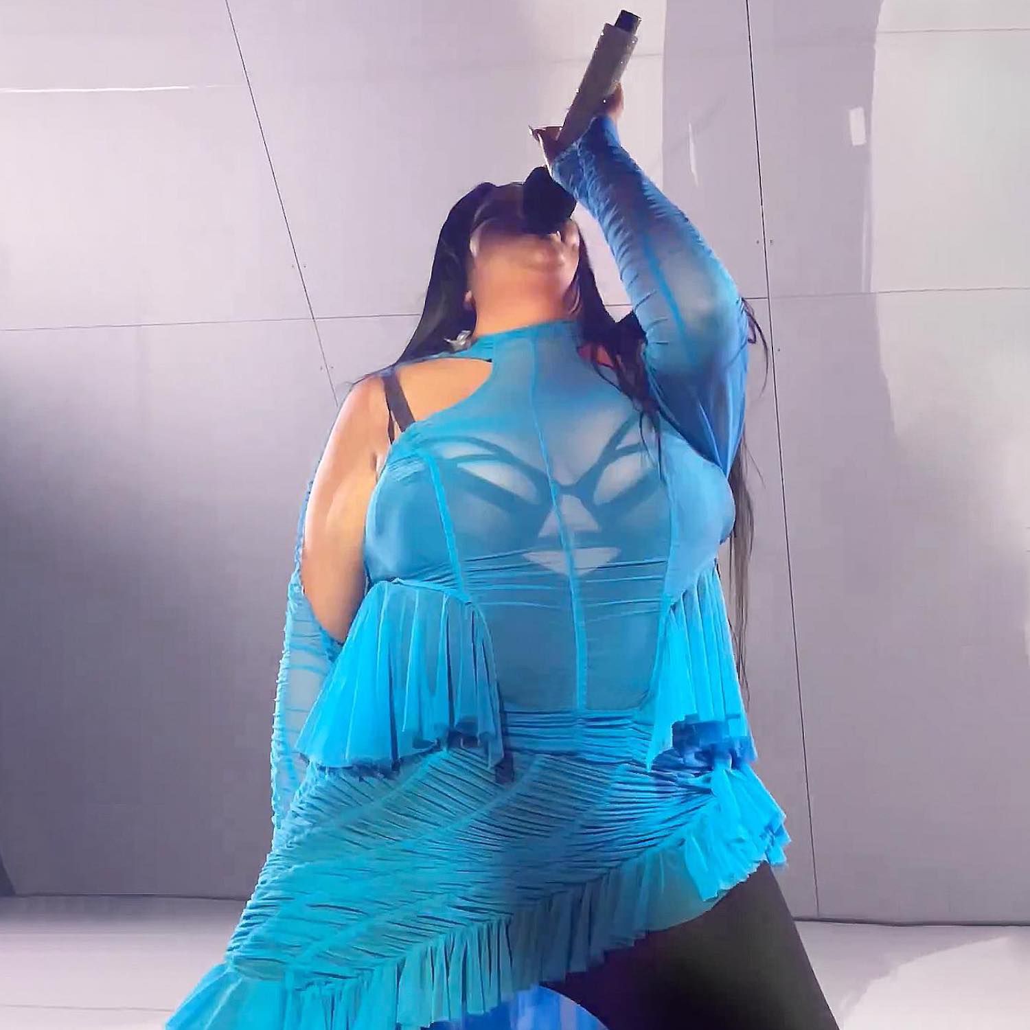 Artista de música shygirl aparece em um vestido azul com babados e corpo preto de estáster manas