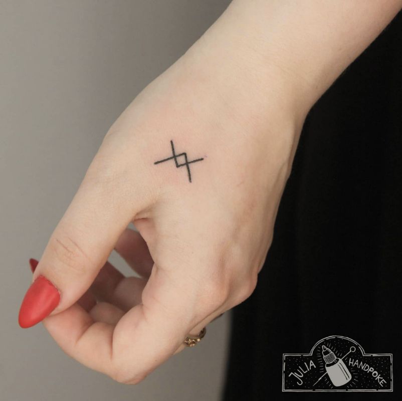 Pequena tatuagem na forma de cruzar flechas no braço