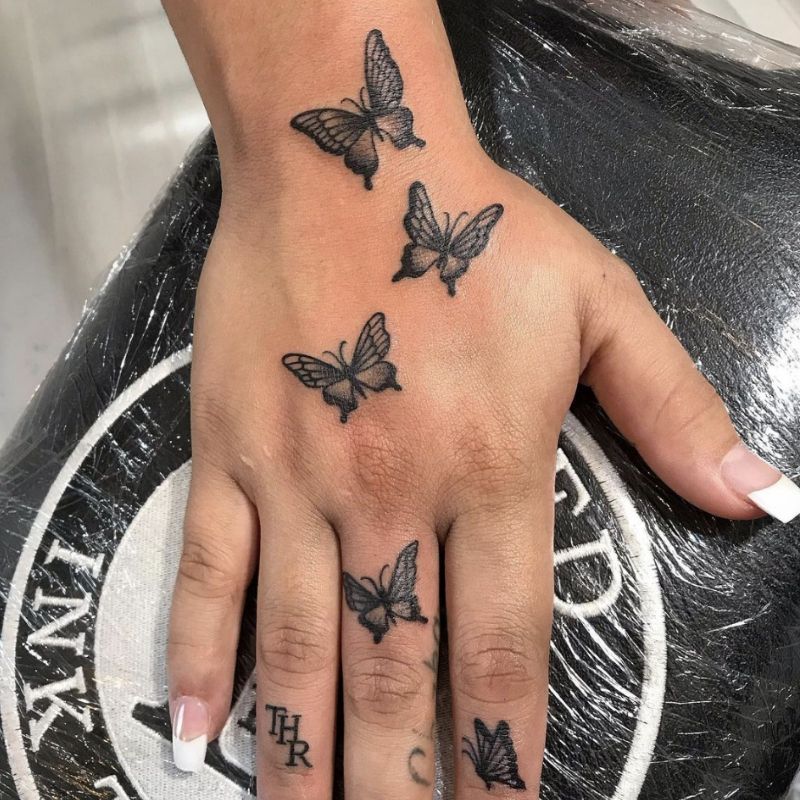 Tatuagens nas mãos na forma de borboletas voadoras