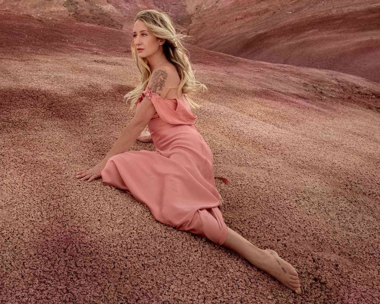 Margot Preço em um vestido rosa dos ombros no deserto.