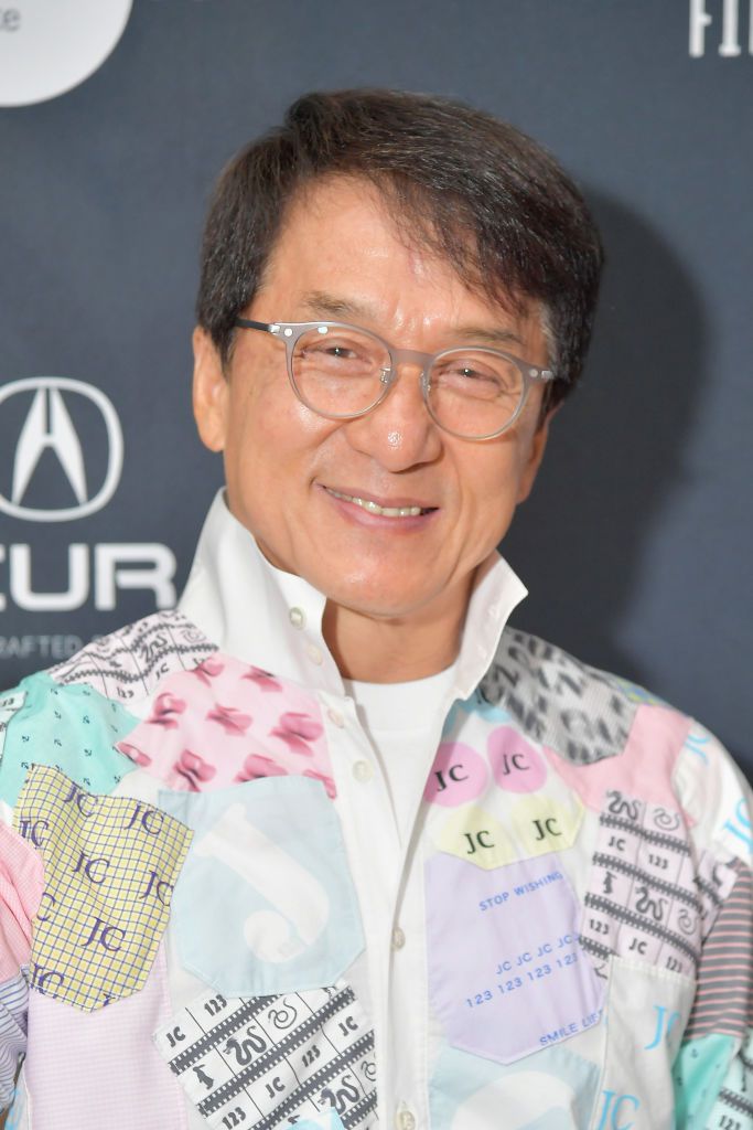Jackie Chan com cabelos curtos de sal e pimenta