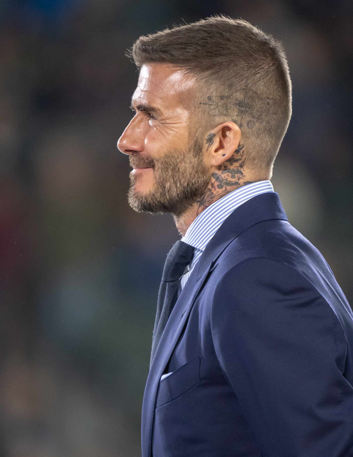 David Beckham demonstra uma tatuagem no couro cabeludo e cortes de corte de cabelo durante a cerimônia de entrar no círculo honorário durante o intervalo da partida da MLS 