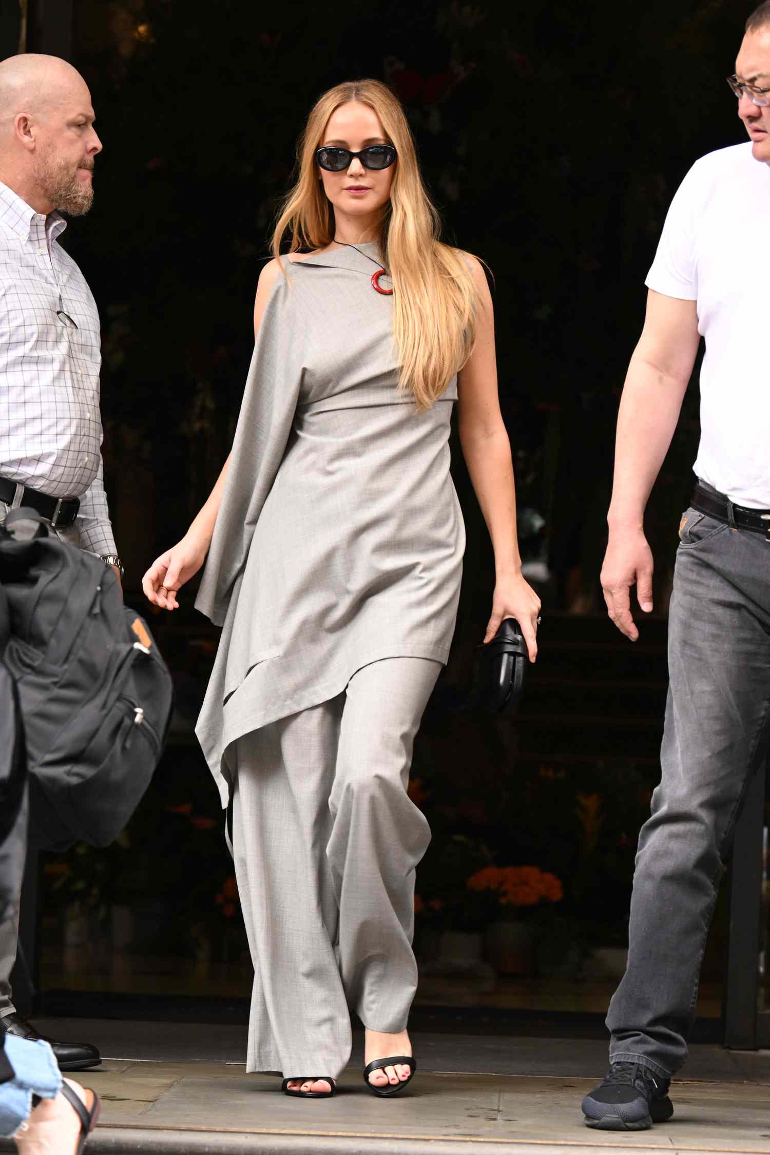 Jennifer Lawrence em uma túnica e calça cinza