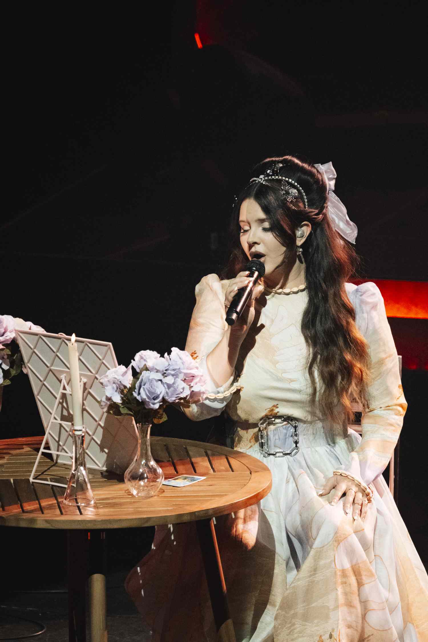 Lana del Rei se apresenta no palco em uma colméia infantil com arcos