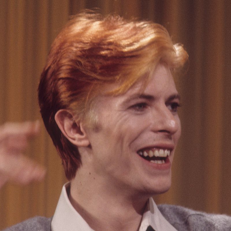 David Bowie usa corte de cabelo curto com penas