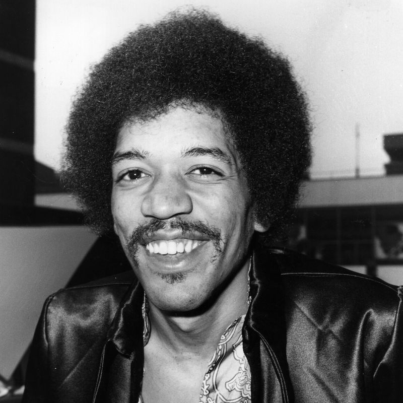 Jimi Hendrix com penteado afro clássico e jaqueta de couro