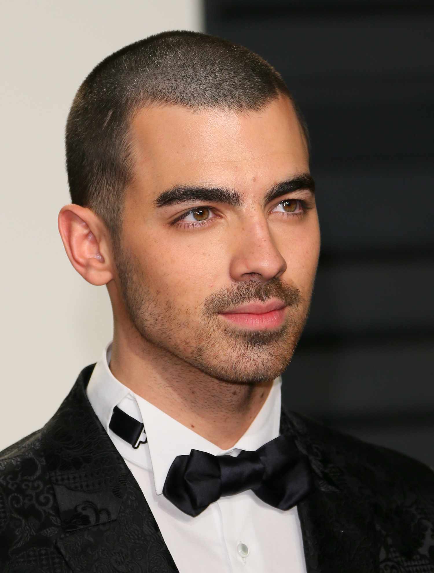 Joe Jonas no Vanity Fair Oscar Party 2017 em um smoking e com um corte de cabelo