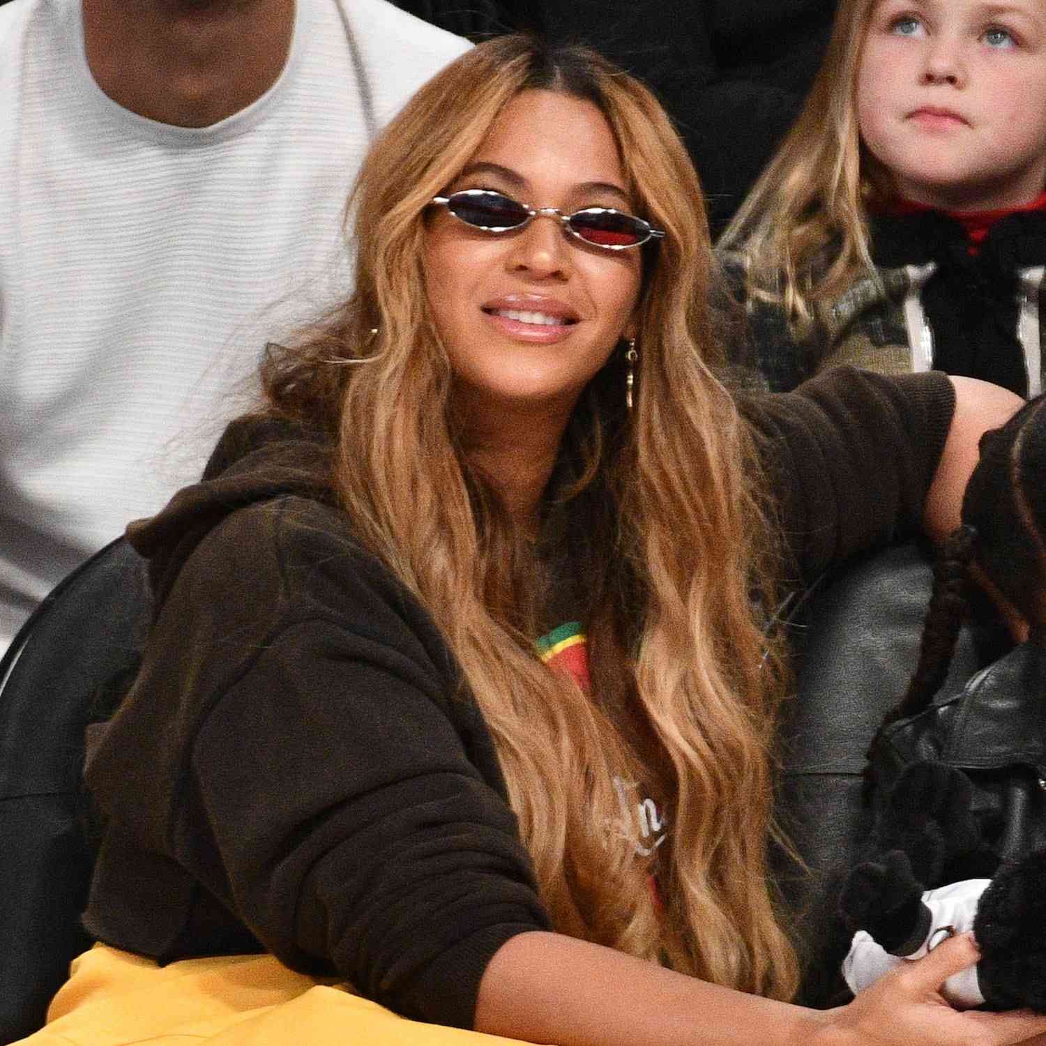 Beyoncé usa um penteado ondulado ultradlin com rostos emoldurando o rosto e pequenos óculos de sol