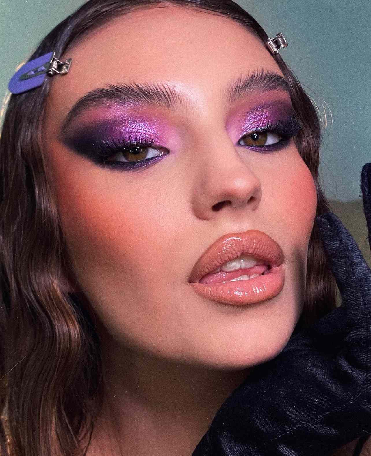 Foto aproximada de uma modelo usando sombra lilás esfumaçada e roxa