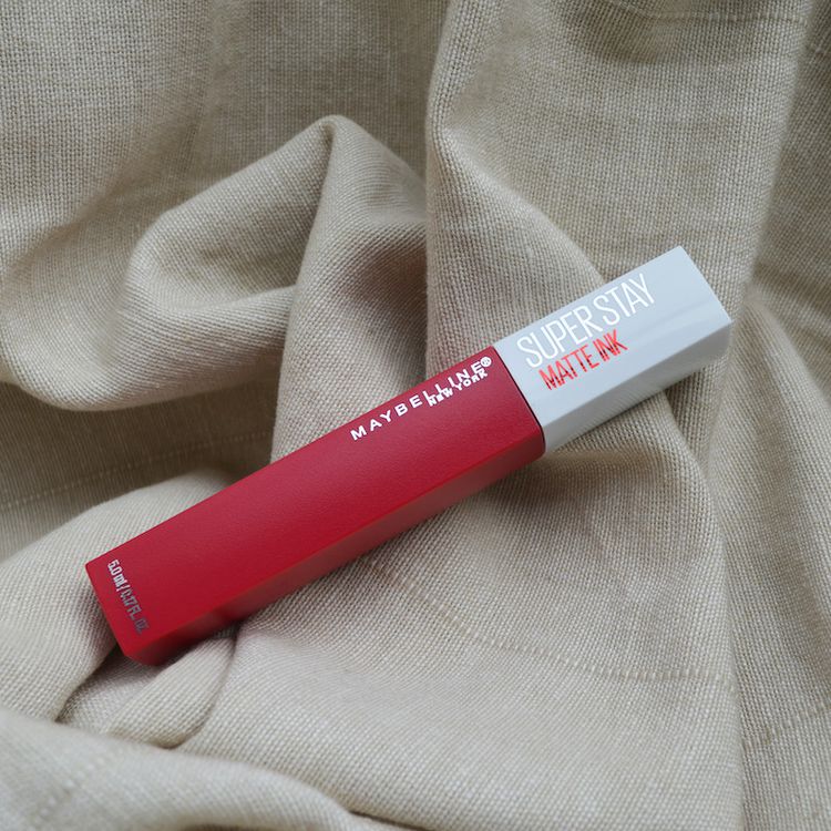 Lipstick Liquid Maybelline Superstay Tim tinta vermelha em um fundo de lenço de papel