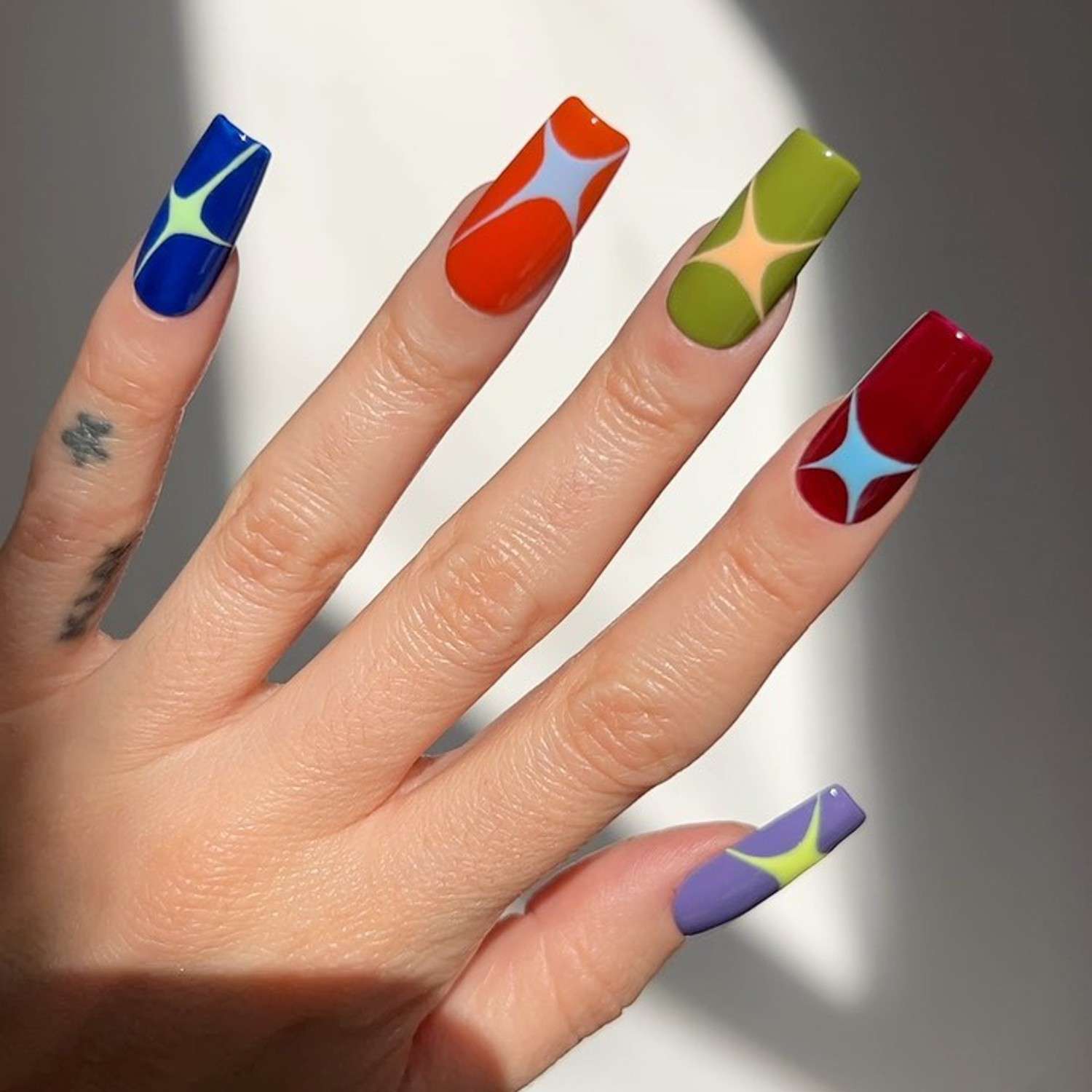 Manicure quadrada multicolorida no estilo dos anos 50