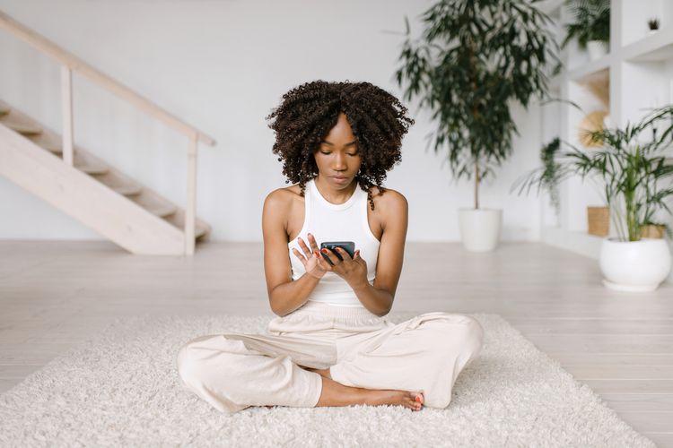 Mulher usando o telefone para meditar