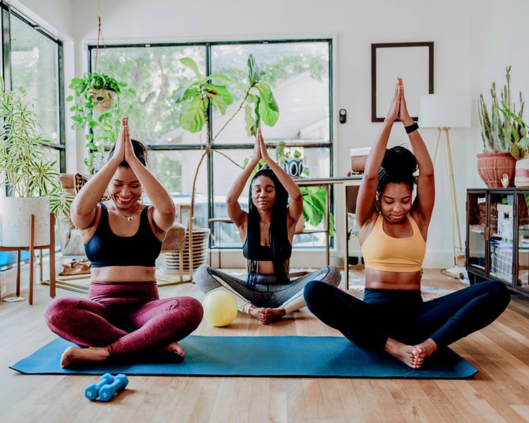 Um grupo de amigos está envolvido em risadas de ioga no apartamento