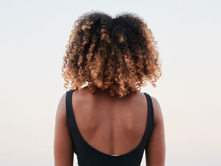 Vista traseira do cabelo afro tingido de uma mulher