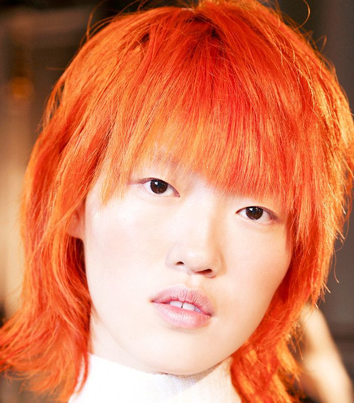mulher com cabelo tingido de laranja