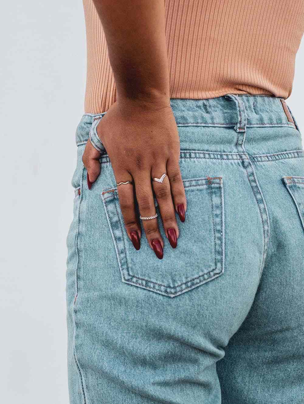 Parte de trás da calça jeans de mulher com as mãos no bolso de trás