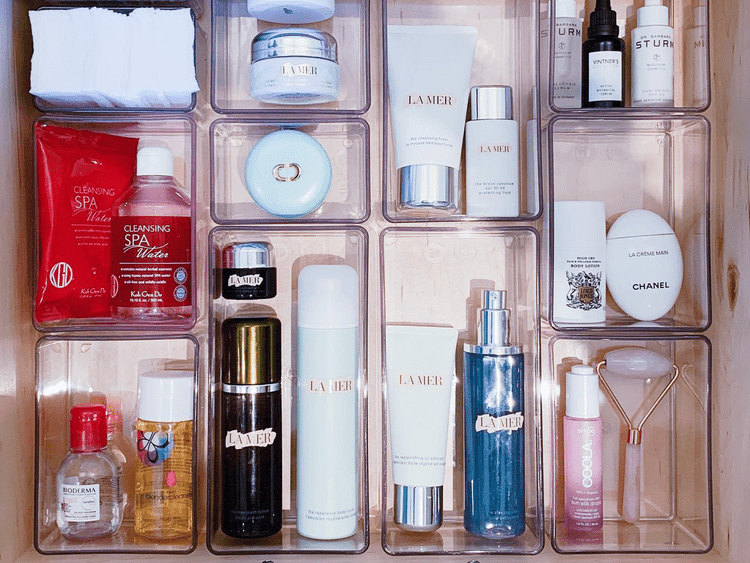 Gaveta com recipientes transparentes cheios de produtos para cuidados com a pele e cosméticos