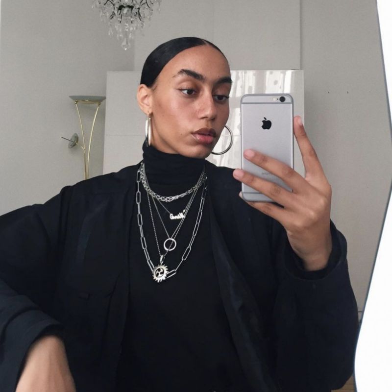 Nisa Maranda Jones faz uma selfie em um espelho com um pacote de costas e jóias de prata